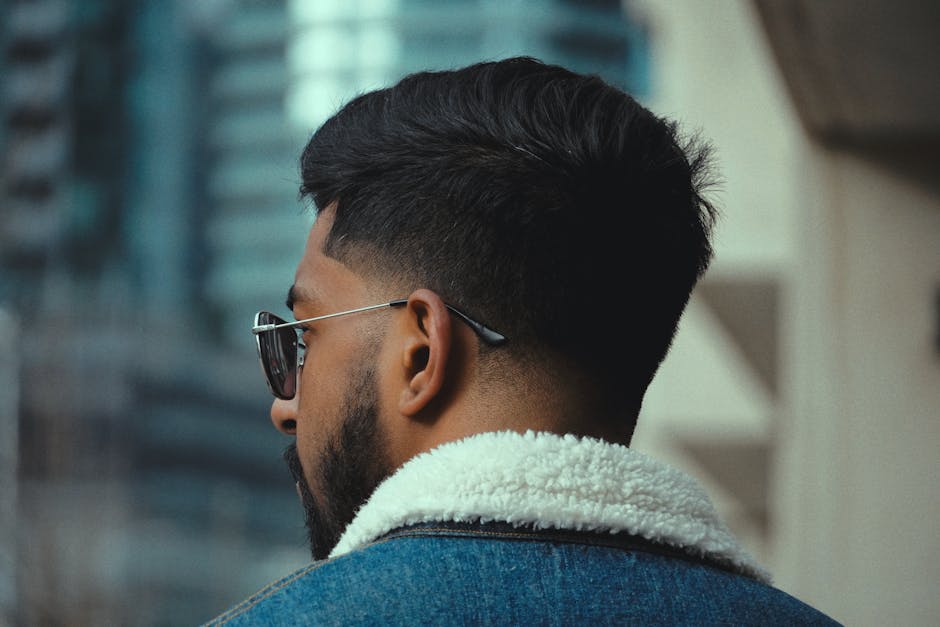 Cool back view portrait of a stylish man in Toronto with sunglasses and a denim jacket.