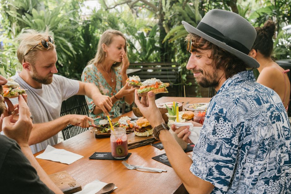 Group of friends enjoying a relaxed meal outdoors, sharing laughs and food.