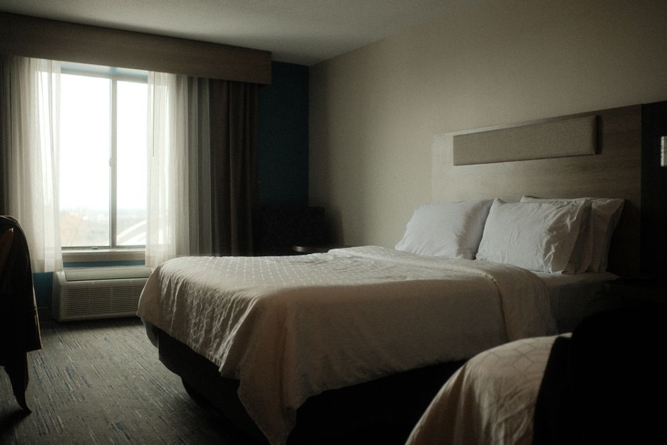 Inviting hotel room interior featuring a comfortable bed and soft morning light filtering through the window.