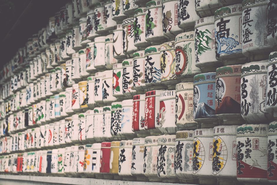 Rows of traditional Japanese sake barrels showcasing colorful labels.
