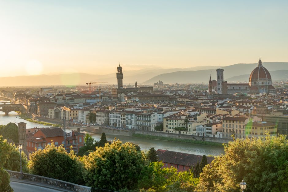 A stunning panoramic view of Florence, Italy, at sunrise featuring the iconic Duomo and Arno River.