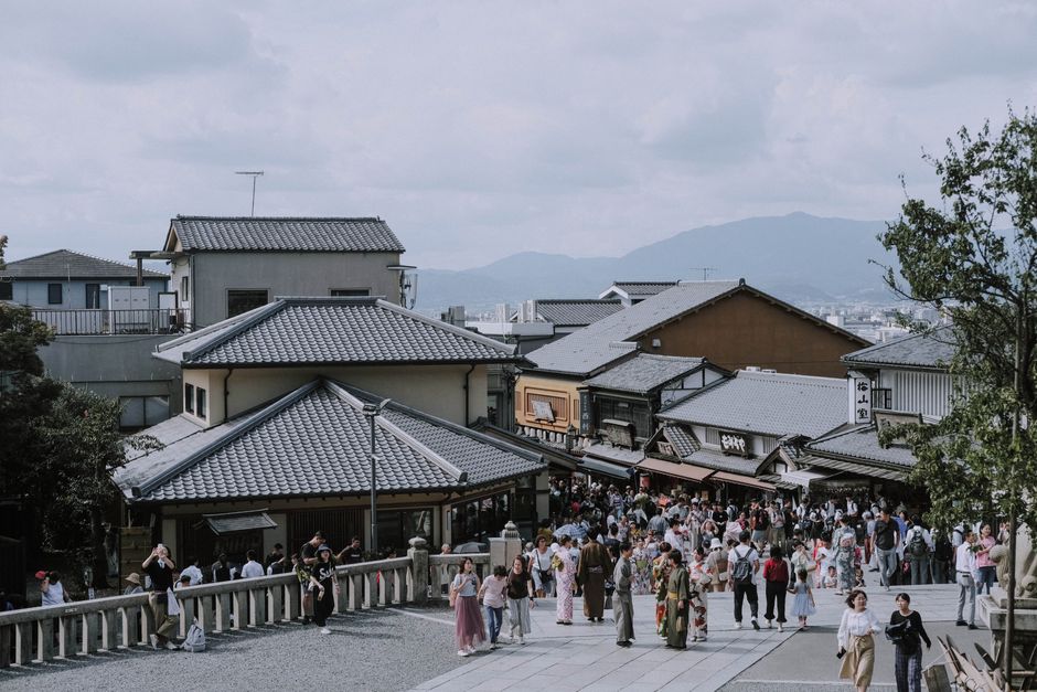 A bustling street in Kyoto with traditional buildings and people wearing kimonos.