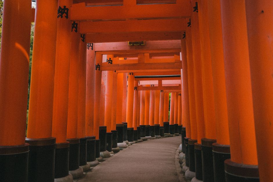 Pathway through vibrant orange torii gates at Fushimi Inari Shrine in Kyoto, Japan.