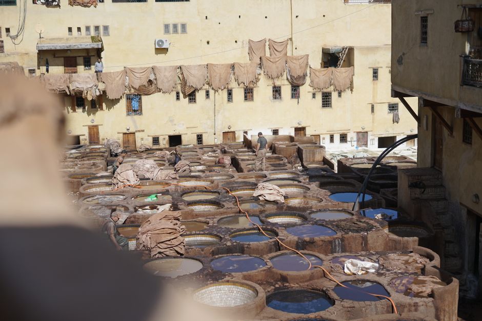View of a traditional leather tannery in Fez, Morocco with tanning pits and drying hides.