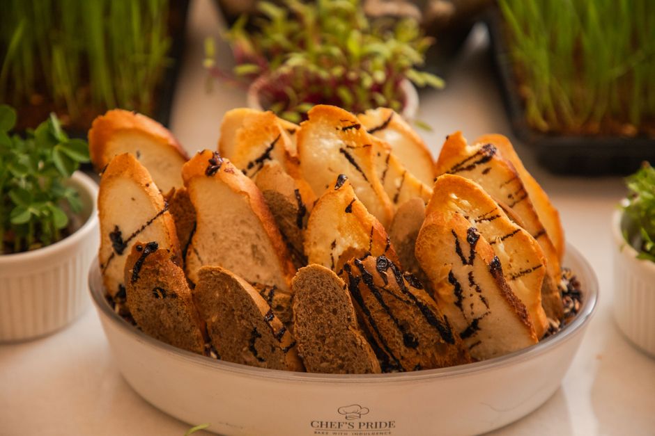 Close-up of an elegant assortment of artisan bread slices presented with fresh herbs, ideal for culinary presentations.